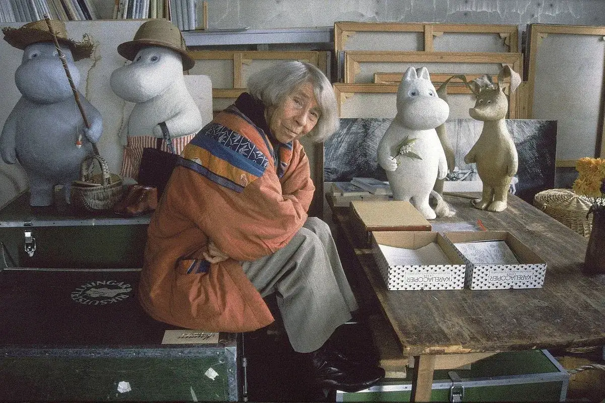 Tove Jansson w otoczeniu Muminków, w pracowni pełnej sztalug i rekwizytów.