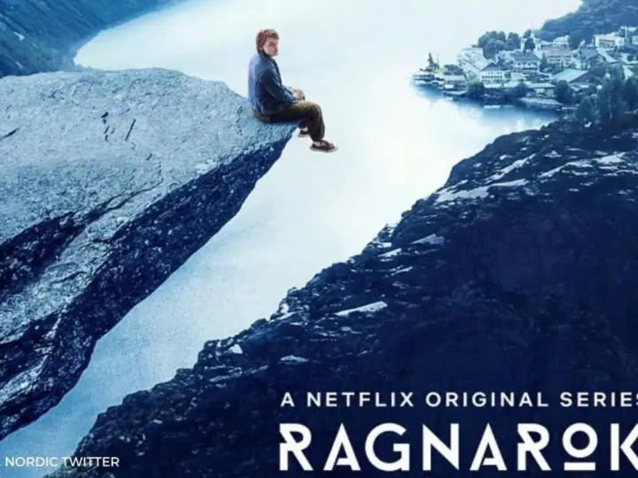 Chłopak siedzi na skale nad jeziorem, w tle miasteczko. Plakat serialu Netflix Ragnarok.